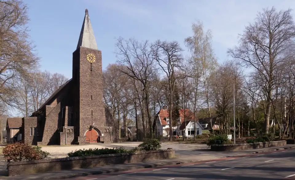 Gereformeerde kerk met bomen en straat in Renkum