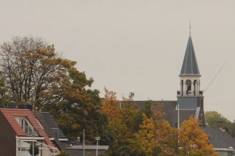 Kerktoren en huizen bij de Merwededijk in Papendrecht